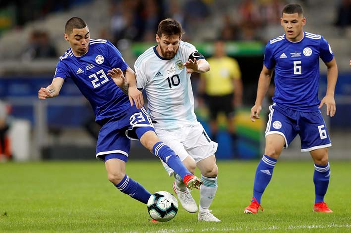 El jugador de Argentina Lionel Messi disputa el balón con Miguel Almiron de Paraguay durante el partido Argentina-Paraguay del Grupo B de la Copa América.