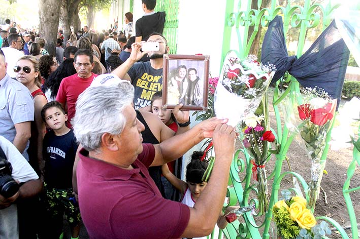 La gente se reúne fuera de la casa de la superestrella mexicana en Ciudad Juárez, al norte de México.  Su publicista dijo que murió a las 11:30 de la mañana en su casa en California.