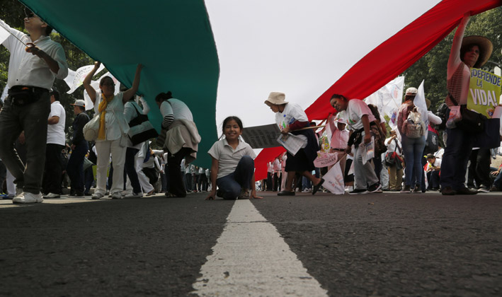 Vestidos en su mayoría de blanco y con globos del mismo color, los manifestantes sostenían carteles con advertencias contra el matrimonio gay.