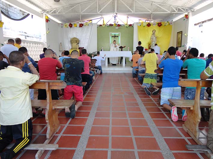 Los internos en la Eucaristía hacen sus plegarias en la capilla Nuestra Señora de las Mercedes en la cárcel.