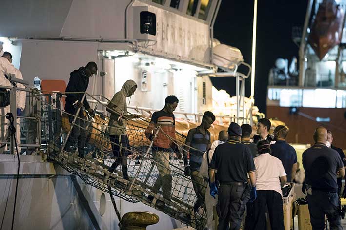 Varios inmigrantes desembarcan de la nave 'Protector', de Frontex (Guardia Europea de Fronteras y Costas), en el puerto de Pozzallo, en Sicilia, Italia. EFE
