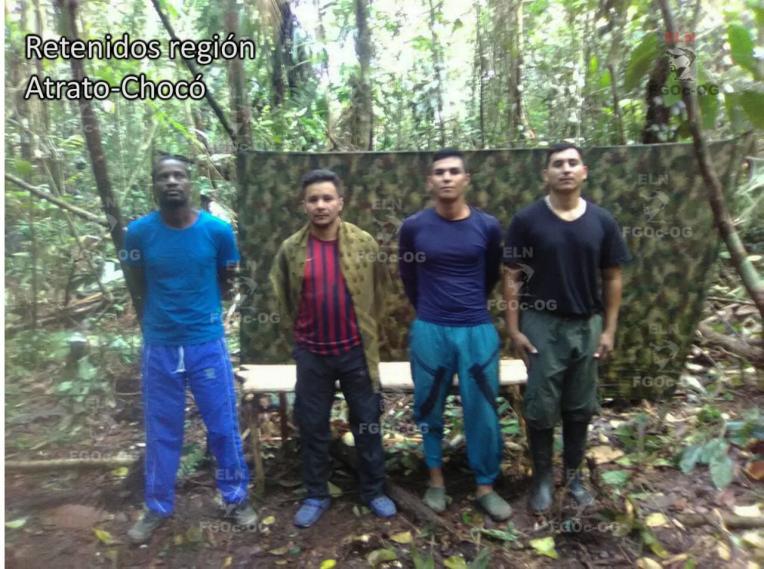 En las imágenes se ve a cuatro hombres vestidos con sudaderas y camisetas de diferentes colores, todos de pie, en medio de una espesa selva, que sería la región del Atrato chocoano. De fondo, hay una bandera verde militar.