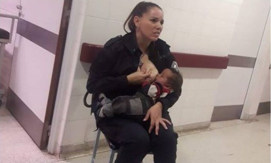 La policía Celeste Ayala, dándole el pecho a un bebé en el hospital de niños de La Plata.