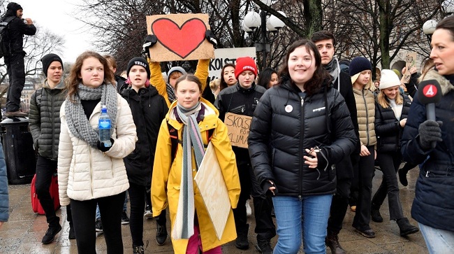 La joven activista ambiental sueca Greta Thunberg (c) y su hermana Beata Thunberg se suman a los cientos de  miles de estudiantes en el mundo que tomaron las calles para reclamar acciones contra el cambio climático.