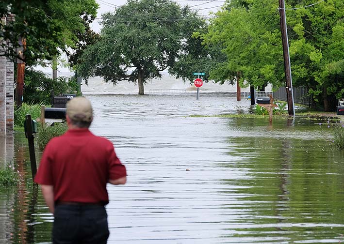 Un hombre mira un camino inundado hacia el lago Pontchartrain, cuando se aproximaba la tormenta tropical Barry, en Mandeville, Louisiana, EE UU. Foto: EFE 