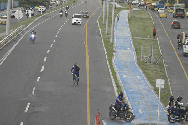  Un ciclista maneja en contravía por el carril rápido de la riesgosa Troncal del Caribe a la altura de la entrada al barrio El Parque, donde hay un puente peatonal y ciclorruta. 