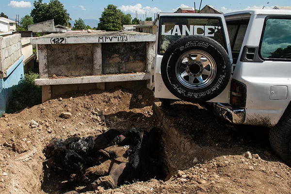 Empleados municipales depositan varios cuerpos en unan fosa común en un cementerio en Puerto Príncipe.