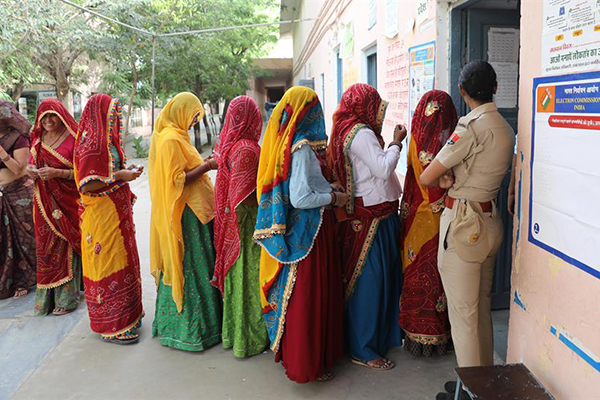 La gente hace cola en un colegio electoral para emitir su voto en la primera fase de las elecciones generales en la aldea de Kotputli en Rajasthan, India.