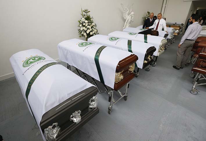 Los empleados funerales colocaron sábanas blancas con un logotipo del equipo de fútbol Chapecoense en los ataúdes que contienen los restos de los miembros del equipo, en Medellín. Las autoridades forenses dicen haber logrado identificar a la mayoría de las víctimas de la tragedia. (Fotos AP).