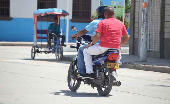 En las principales avenidas de la ciudad transitan en motocicleta dos hombres, infringiendo la norma sin ningún problema.