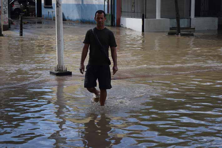 Peatones tuvieron que lidiar con las inundaciones en las calles.