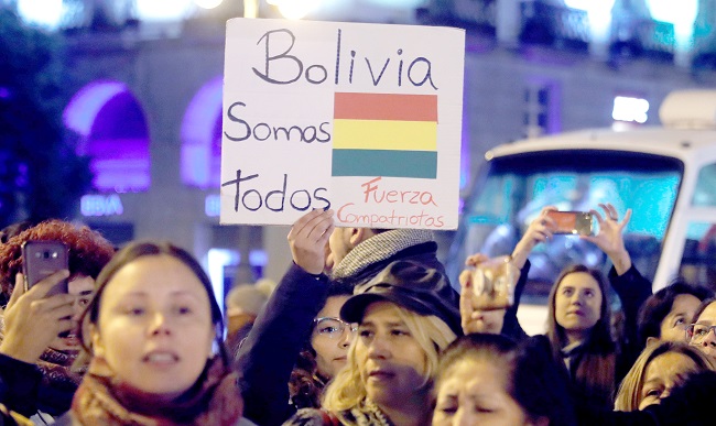 Varias personas se concentran mientras ondean banderas de Bolivia, este lunes, en la Puerta del Sol de Madrid. Foto: EFE