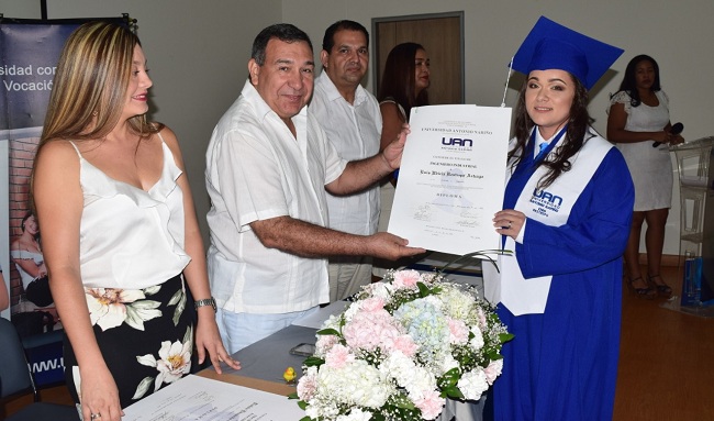 Inés Restrepo de la carrera de Ingeniería Industrial, recibiendo su diploma por parte de los directivos de la institución.
