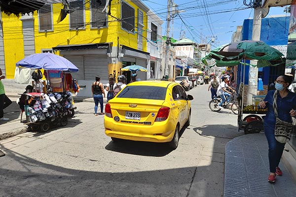 Calle Cangrejal (Calle 12): Una calle estrecha invadida por comerciantes ambulantes que afectan el paso vehicular.