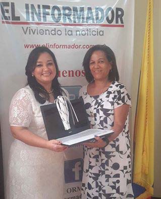 Tatiana Patricia Serrano Olmos, secretaria de la Universidad Sergio Arboleda recibiendo de manos de Mirian Arango su premio.