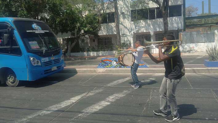 Jesús Armando Ospino  y Armenio Seguro, en un semáforo de la ciudad, tocan sus instrumentos (trombón y tambor gallego).