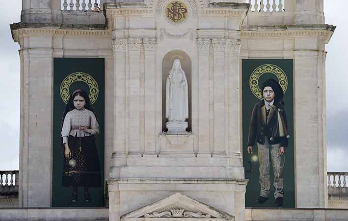 Las fotos de Jacinta y Francisco Marto colgaron de la fachada del Santuario de Nuestra Señora de Fátima en Portugal. Las visiones de la Virgen por parte de los dos niños hace 100 años marcaron uno de los eventos más importantes de la Iglesia Católica del siglo 20.