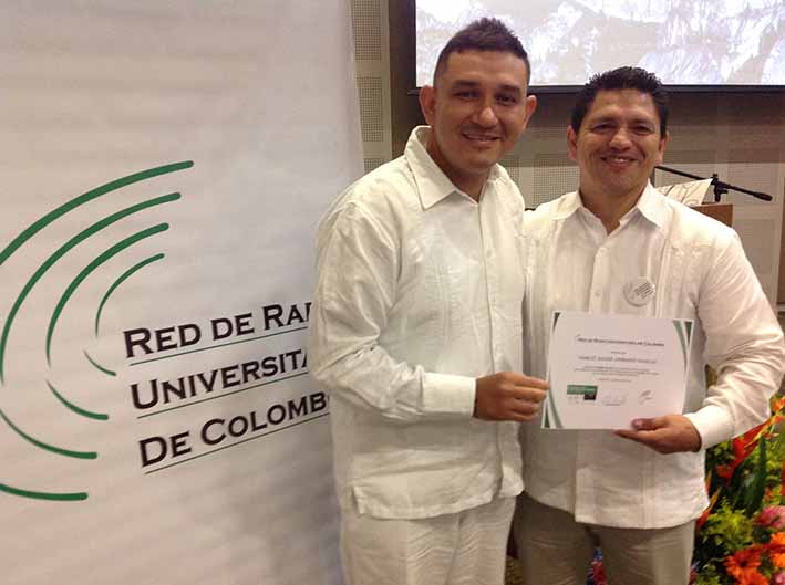 El coordinador de Unimagdalena Radio, Hamlet Lombardi, recibiendo el premio de parte del residente de la Red Elhier Hernández.