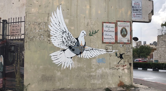 Una paloma de la paz con chaleco antibalas y un visor de un francotirador dibujado sobre su pecho en la ciudad de Belén, Cisjordania, obra de Bansky, cerca del hotel. 