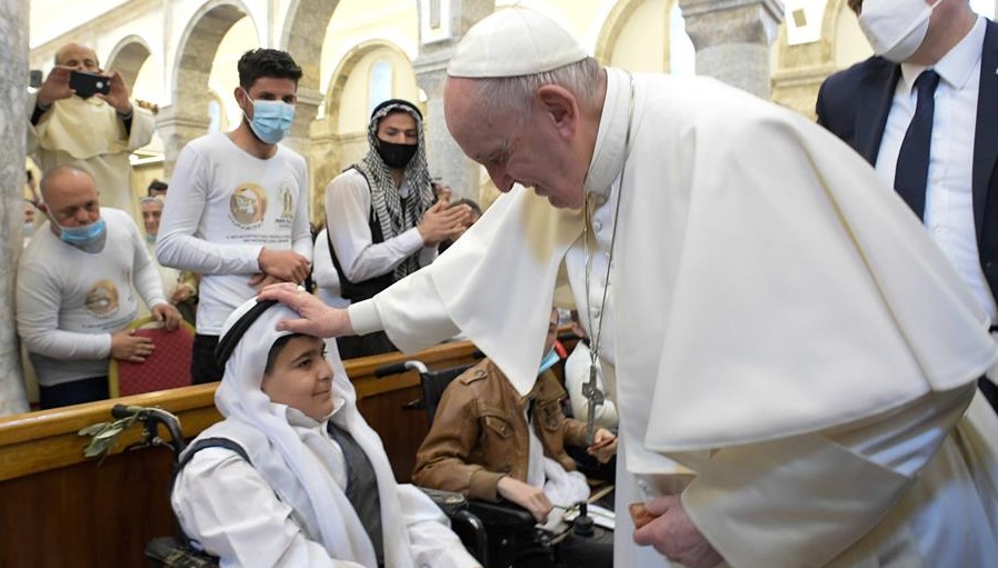 El Santo Padre da la bendición a un joven en la Iglesia católica siríaca de la Inmaculada Concepción. 