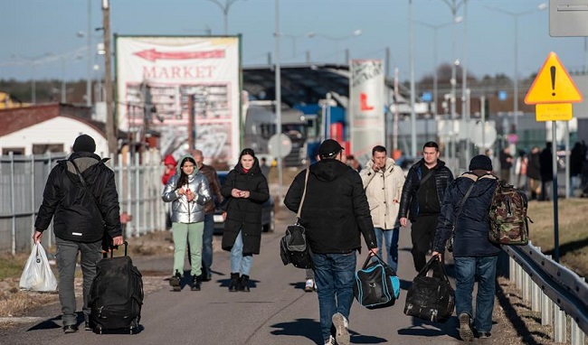 La gente camina cerca del cruce fronterizo polaco-ucraniano en Dorohusk para escapar de la arremetida de Rusia.