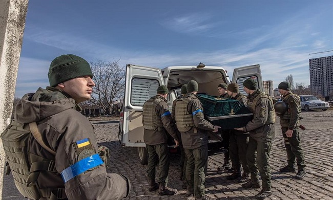 Miembros del ejército ucraniano llevan el ataúd cerrado con el cuerpo de Roman, un soldado de ese país caído en la región de Kiev durante la invasión rusa de Ucrania, en el servicio de cremación en un crematorio.