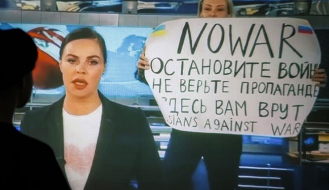 Una periodista rusa entra en directo en el estudio de televisión de Ostankino con un póster que dice