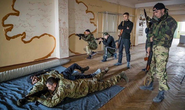 La fotografía muestra a un grupo de voluntarios participar en una clase en un campo de entrenamiento ubicado en las inmediaciones de Kiev.