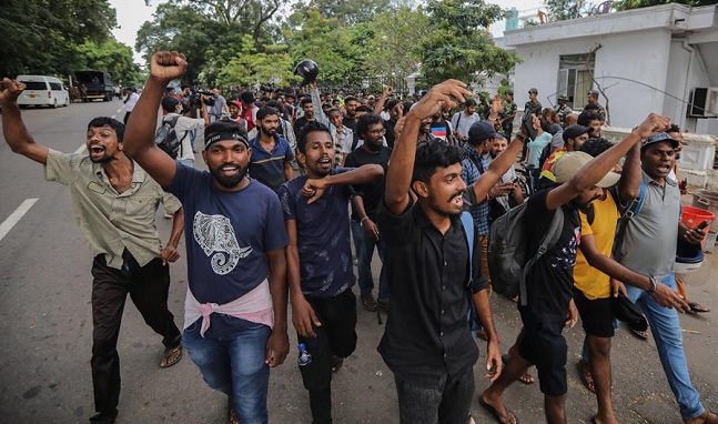 Los manifestantes animan y gritan consignas después de abandonar la oficina del primer ministro en Colombo, Sri Lanka.