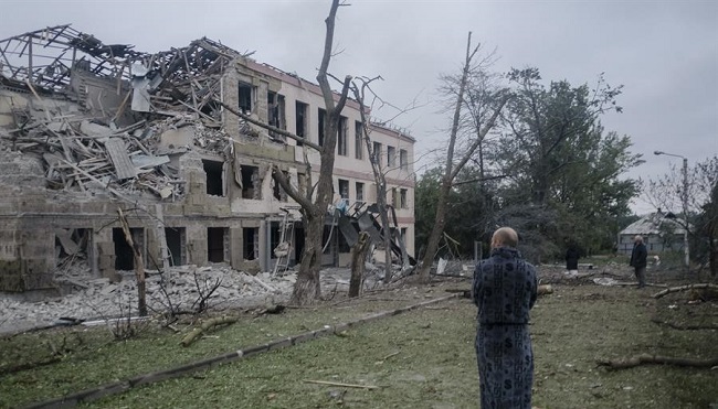Los lugareños se paran frente a una escuela dañada después de que un ataque con misiles golpeó la ciudad de Kramatorsk, región de Donetsk.