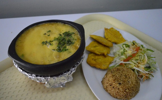 Cazuela de mariscos acompañada con patacones de plátano verde, arroz con coco y ensalada. 