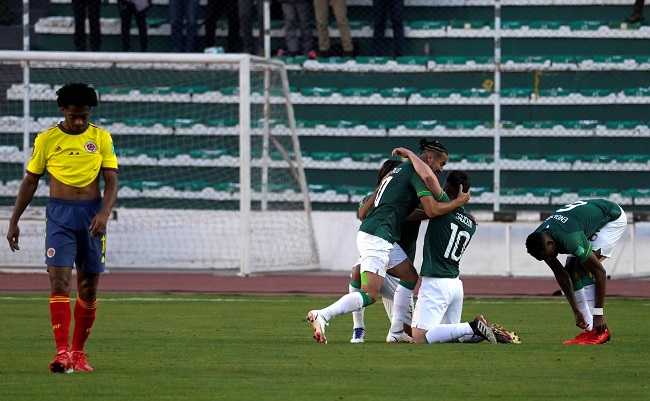 Juan Guillermo Cuadrado se lamenta, mientras que los bolivianos festejan el gol del empate.