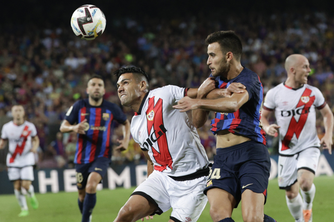  El delantero colombiano del Rayo Vallecano Radamel Falcao (i) lucha con el defensa del FC Barcelona Eric García, durante el partido correspondiente a la primera jornada de LaLiga que FC Barcelona y Rayo Vallecano disputan hoy sábado en el Camp Nou, en Barcelona. EFE/