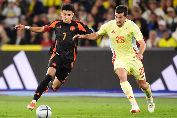 Luis Díaz en un momento de acción durante el partido, corriendo con el balón mientras evade a los defensores rivales. Luis Díaz en un momento de acción durante el partido, corriendo con el balón mientras evade a los defensores rivales.