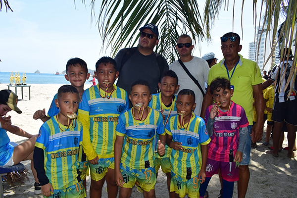 Participantes del Torneo Comunitario de Fútbol Playa posan orgullosos con sus trofeos y medallas, destacando la participación de más de 1.500 niños de diferentes barrios de Santa Marta.