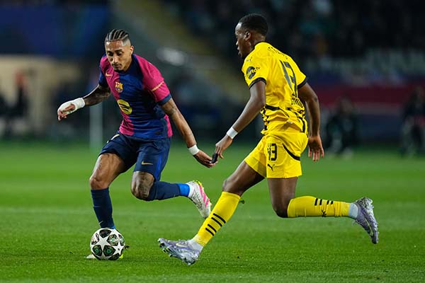El delantero del Barcelona Raphinha (i) juega un balón ante Jamie Gittens, del Dortmund, durante el calentamiento previo al partido de ida de cuartos de final de la Liga de Campeones que FC Barcelona y Borussia Dortmund disputan este miércoles en el Estadio Olímpico Lluis Companys. EFE/Siu Wu
