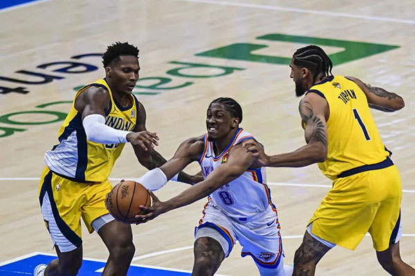 Jalen Williams, alero de los Oklahoma City Thunder lanzando contra los dos aleros de los Indiana Pacers. Foto EFE