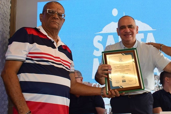 Cesar Augusto Corbacho recibiendo la placa en homenaje por parte de Carlos Pinedo Cuello, Alcalde Distrital.