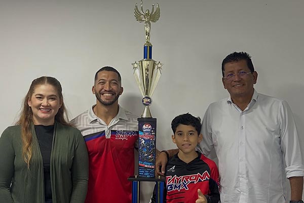 Luis Ángel Rocha, joven samario Campeón de ciclismo Bmx en Estados Unidos recibiendo un reconocimiento deportivo por parte de Hideraldo Espinosa, director de Inred, en compañía de su madre y su entrenador. Foto Inred 