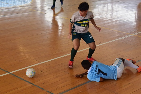 Joven estudiante del Colegio San Luis Beltrán enfrentando a un rival del IED La Paz en fútbol sala. Foto derechos reservados EL INFORMADOR