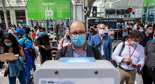Un pasajero frente a una cámara de medición de temperatura corporal colocada en una plataforma en la estación de tren Gare de Lyon en París. 
