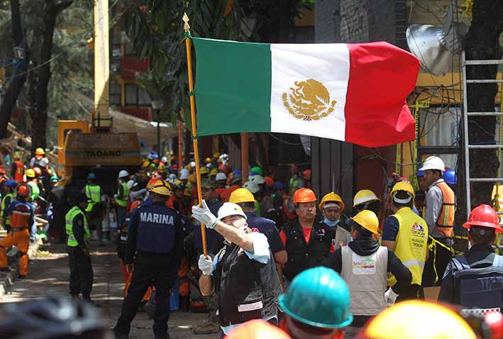 Un miembro de las brigadas de rescate ondea una bandera mexicana durante las labores de búsqueda de desaparecidos, en un edificio de la colonia Taxqueña en Ciudad de México (México).