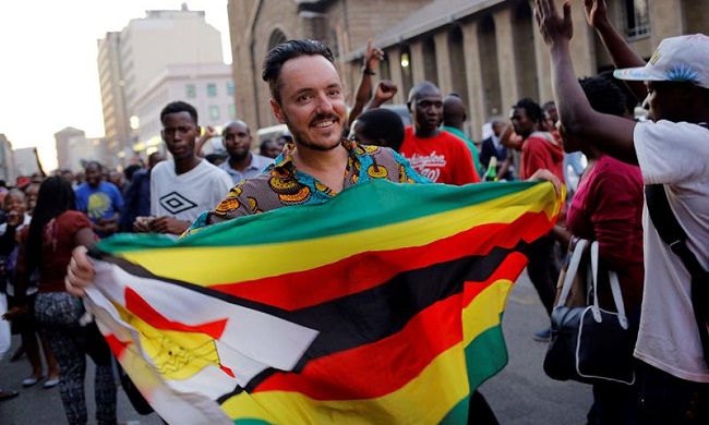 Manifestantes celebran la dimisión de Robert Mugabe como presidente en las inmediaciones del Parlamento en Harare (Zimbabue)