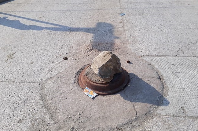La comunidad como prevención volteo la tapa y coloco una gigantesca piedra encima.