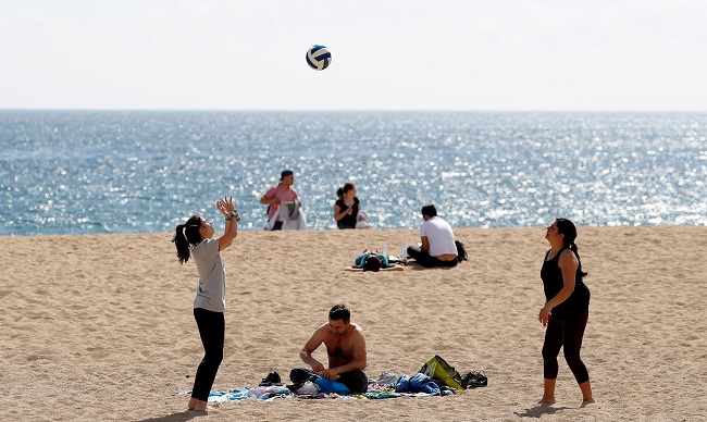 Varias personas disfrutan en la playa de Barcelona tras las restricciones a la libertad de circulación. EFE