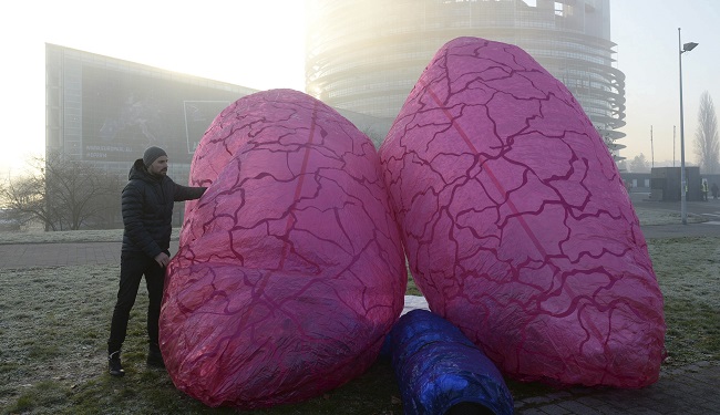 Un miembro de la Asociación Alemana de Protección de la Naturaleza (NABU) coloca unos pulmones gigantes simbólicos en las inmediaciones del Parlamento Europeo.