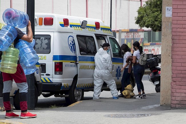 Un trabajador sanitario asiste a personas afuera de un hospital en Caracas (Venezuela). EFE