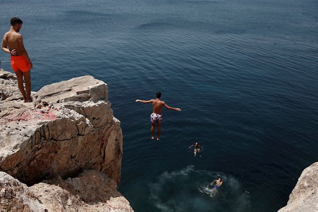 Un hombre se sumerge en el mar durante una ola de calor en Varkiza, cerca de Atenas, (Grecia).