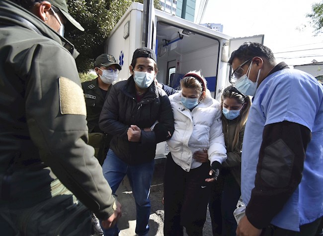  La expresidenta de Bolivia, Jeanine Áñez, camina hoy acompañada por sus hijos José Armando Ribera (i) y Carolina Ribera (d) hacia un centro médico para realizarse unos exámenes, en La Paz (Bolivia). EFE