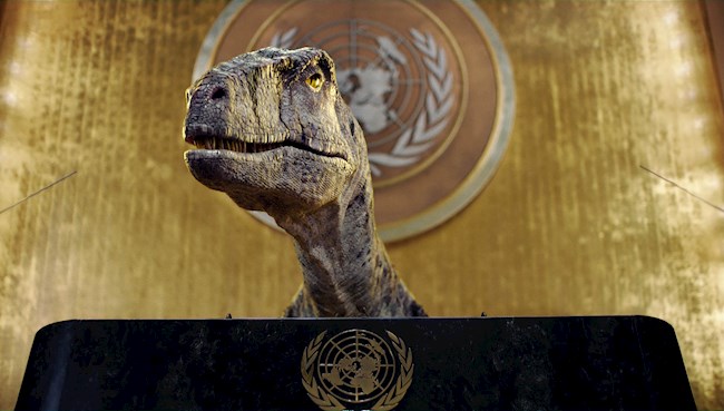 Fotografía cedida por el Programa de Naciones Unidas para el Desarollo (PNUD) en su cuenta de Twitter donde aparece Frankie, un dinosaurio generado por computadora mientras habla tras irrumpir en el famoso salón de la Asamblea General de la ONU en Nueva York (EEUU).